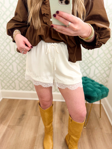 These soft ivory shorts feature a comfortable elastic drawstring waist with delicate lace trim along the hem for a feminine finish