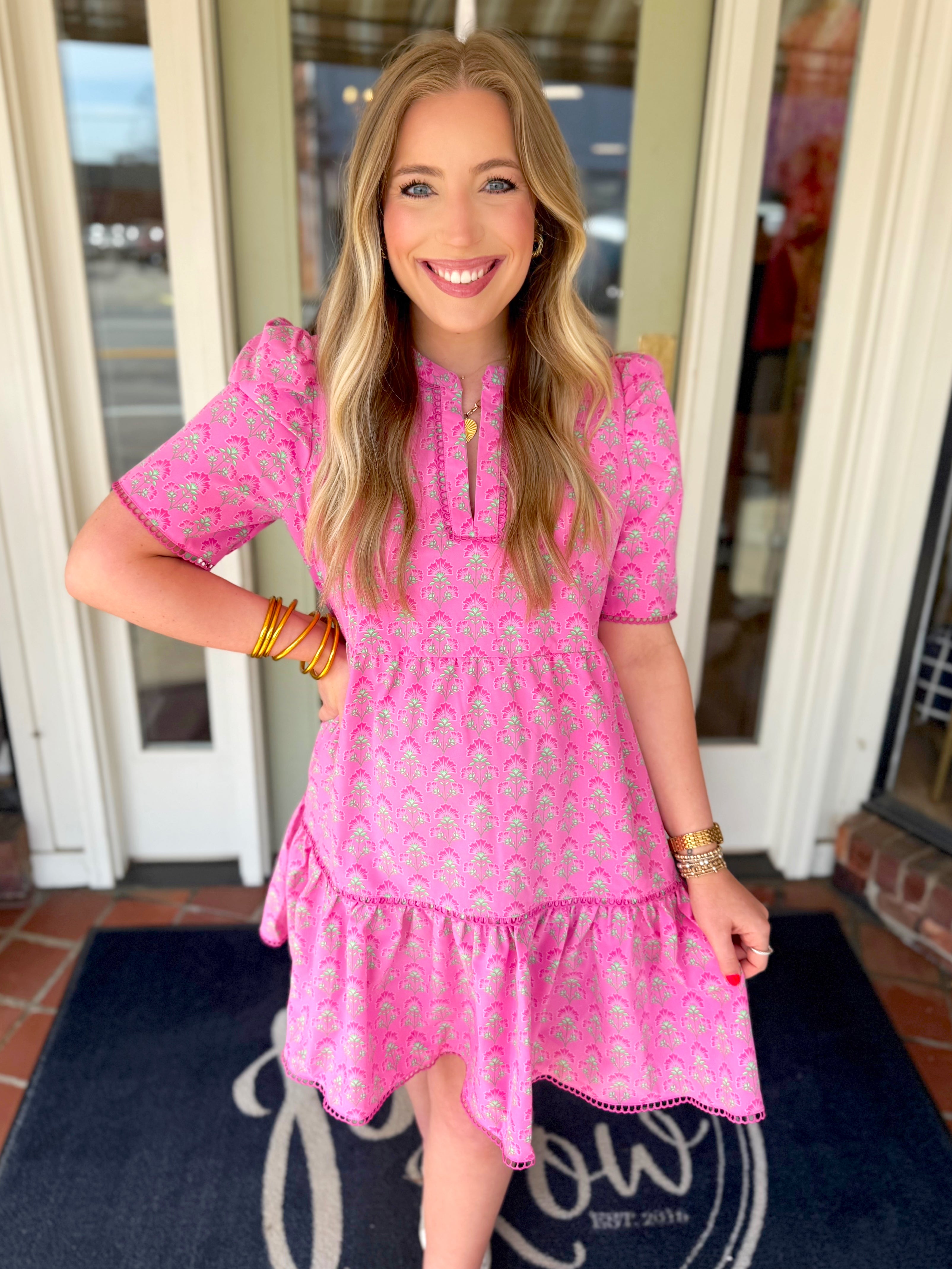 Pink mini dress with a floral pattern and lace detailing on the trim of the dress 