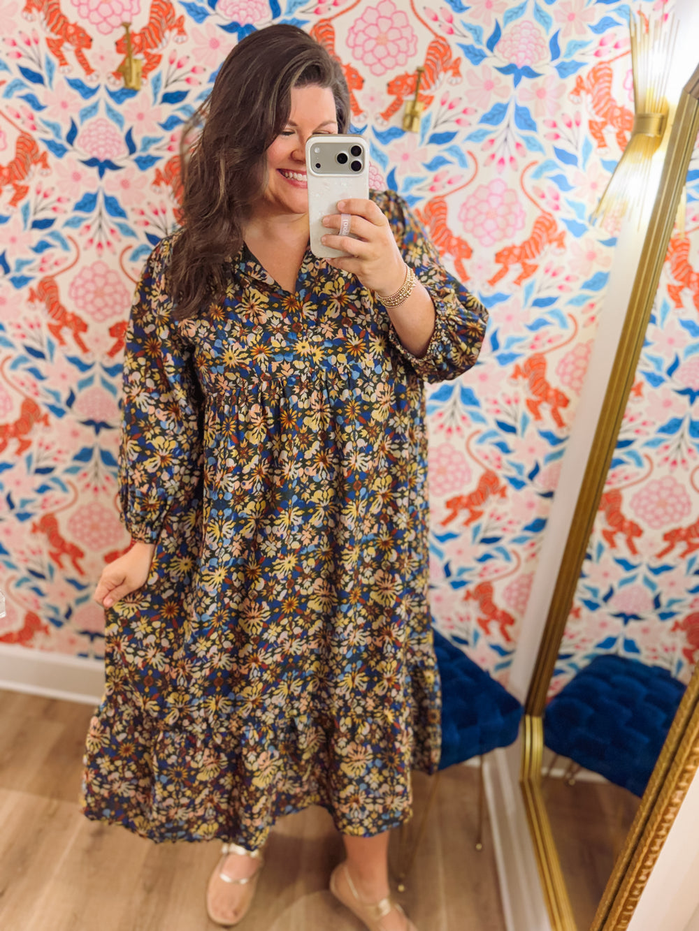 This midi dress features an allover vintage-inspired floral print in shades of navy, blue, golden yellow, and warm brown.