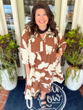 This maxi dress features an allover floral print with a tiered silhouette that gives it beautiful movement. The split V-neckline is finished with a feminine ruffle collar for an extra special touch. 