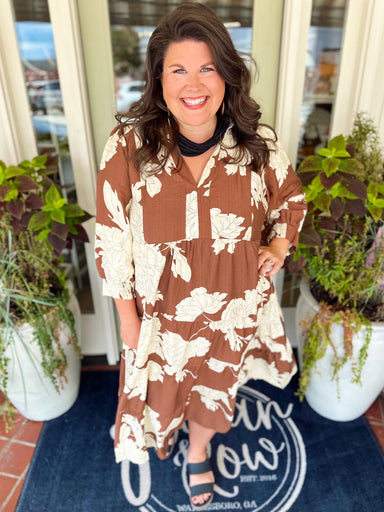 This maxi dress features an allover floral print with a tiered silhouette that gives it beautiful movement. The split V-neckline is finished with a feminine ruffle collar for an extra special touch. 