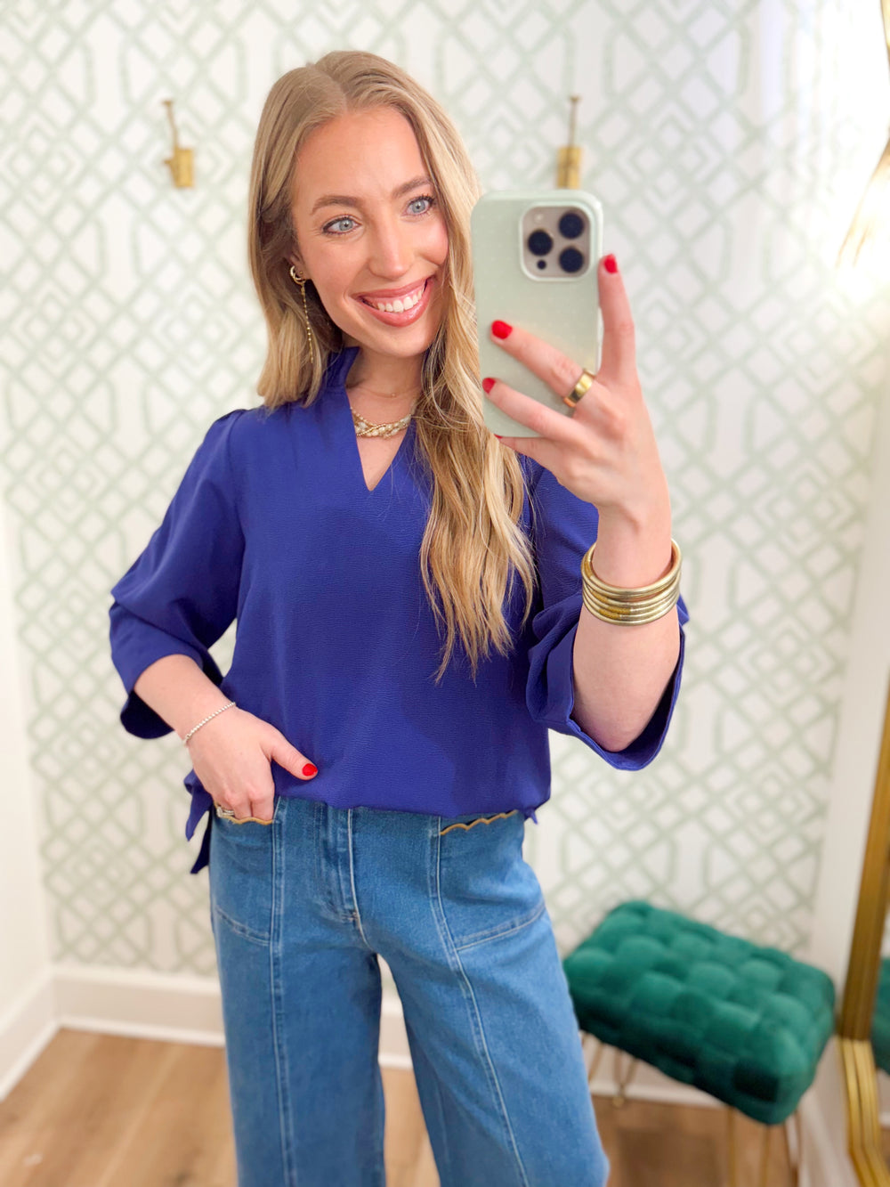  This top features a rich purple hue with a flattering V-neckline and feminine ruffle collar detail. 