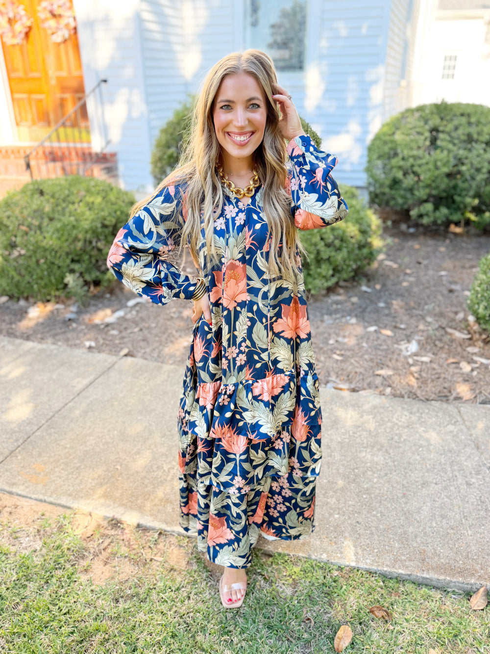 This dress features a beautiful allover floral print with a ruffled split neckline, feminine self-tie detail, and long sleeves.