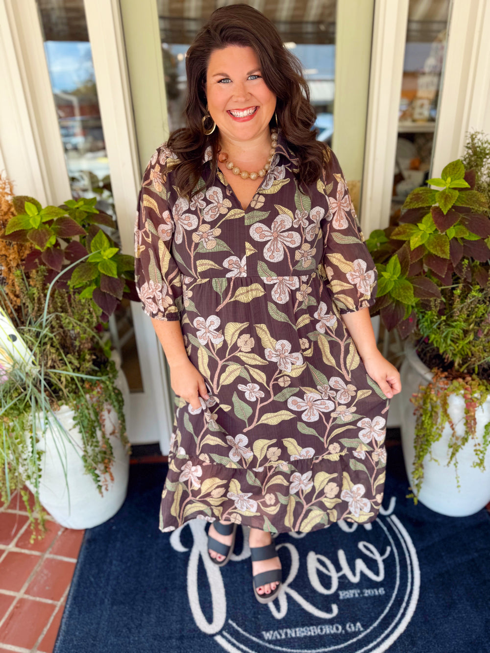 This floral dress features a mix of rich brown hues throughout with a flowy tiered silhouette that gives it plenty of movement.