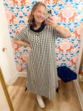 This dress features a black and cream check print with a relaxed maxi silhouette, short sleeves and a collared neckline.