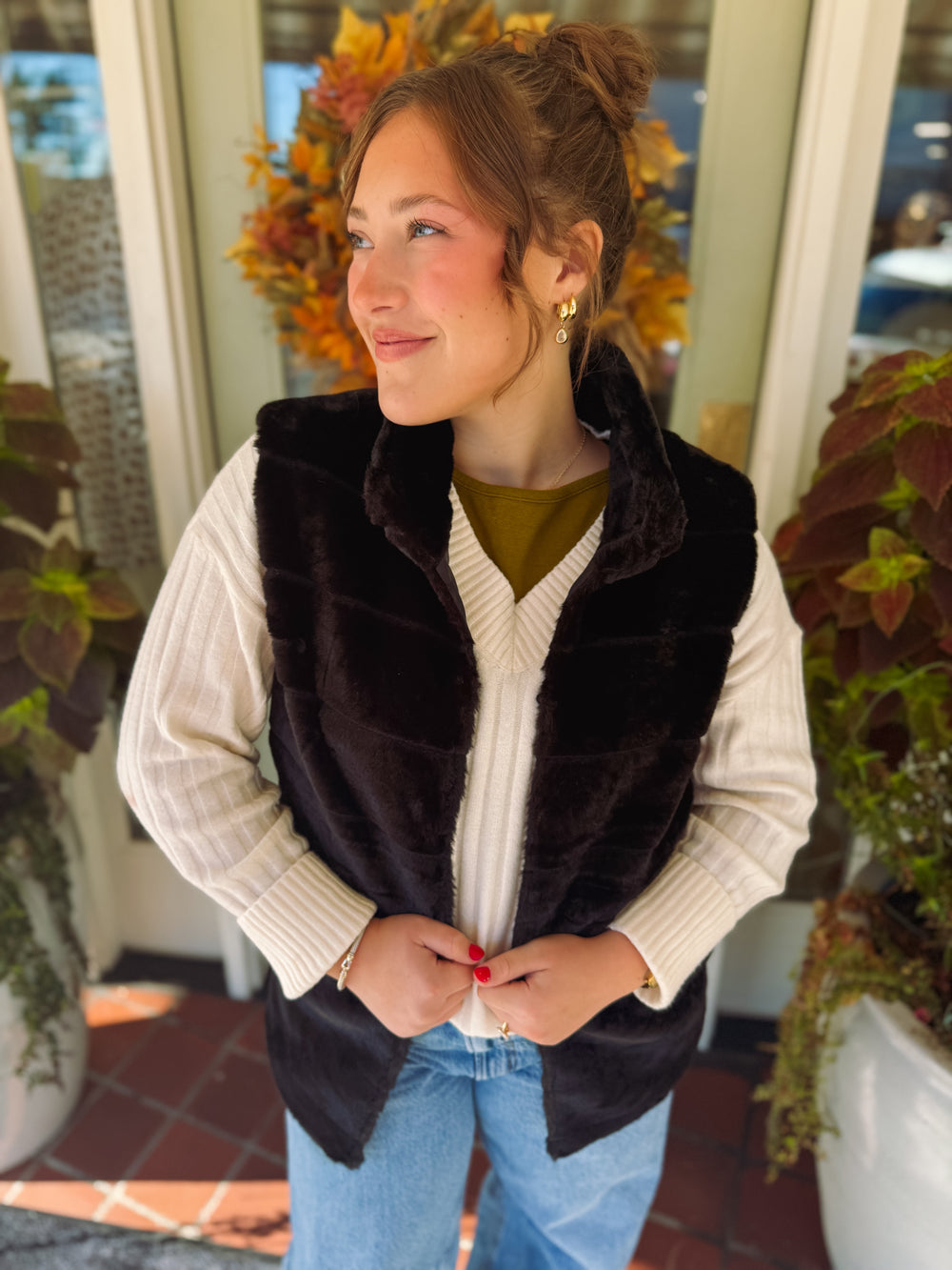 black lined fur vest with one hook to close it 