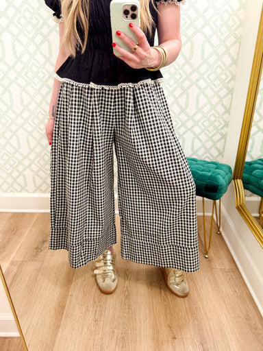 These black and cream gingham pants feature a relaxed wide-leg silhouette with pretty pleated detailing for a little extra shape and movement. 