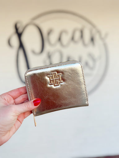 A sleek gold zip wallet with a gold CH on the front of it 
