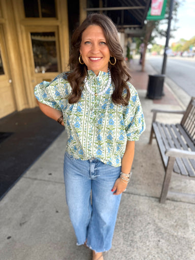 A light green and blue floral patterned blouse with puff sleeves.