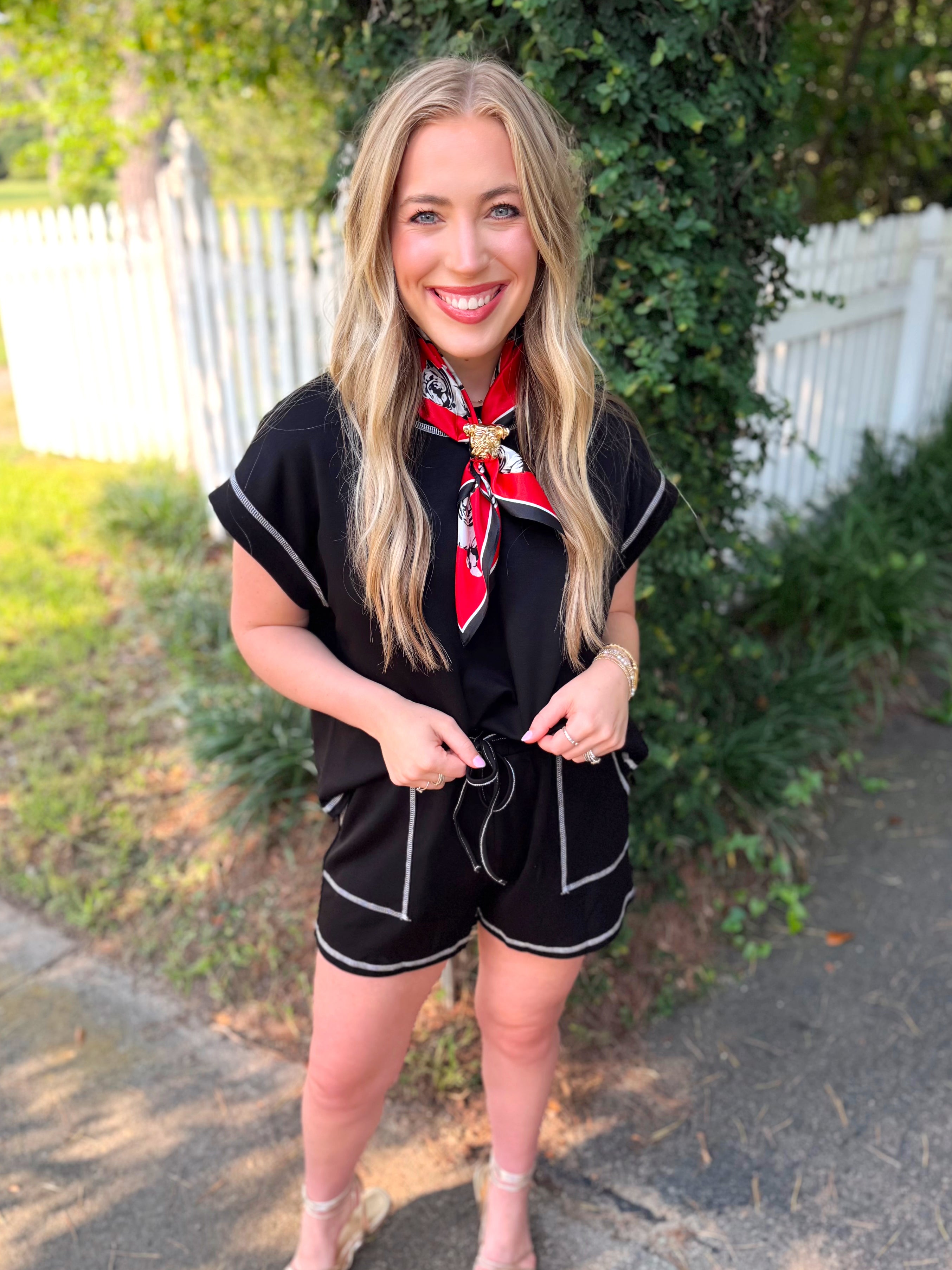 A black short-sleeve top with white piping on it.