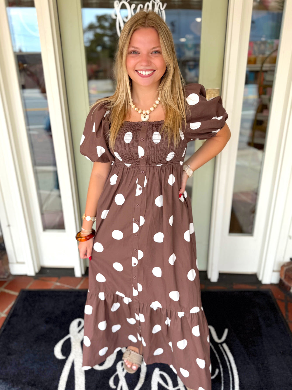 A brown and white polka dot midi dress with puff sleeves