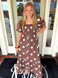 A brown and white polka dot midi dress with puff sleeves