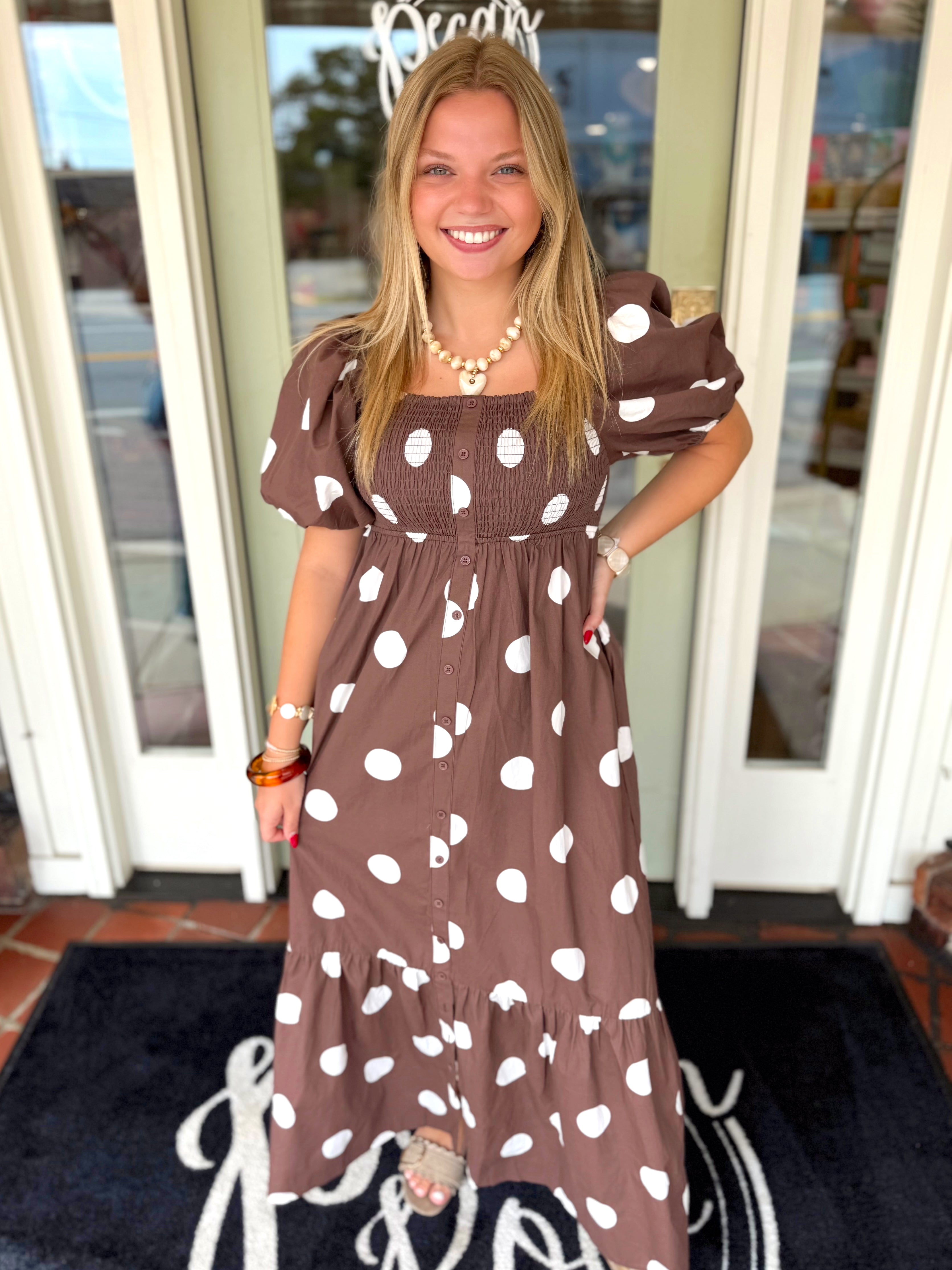 A brown and white polka dot midi dress with puff sleeves