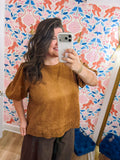 This camel top features a relaxed silhouette with short puff sleeves, subtle seam detailing, and beautiful embroidered cutout detail along the scalloped hem.