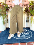 Olive green high rise pants with a ruffle detail at the bottom