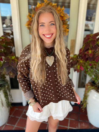 This brown knit cardigan features cream polka dots throughout with a button-front design that makes it just as cute worn alone as it is layered.