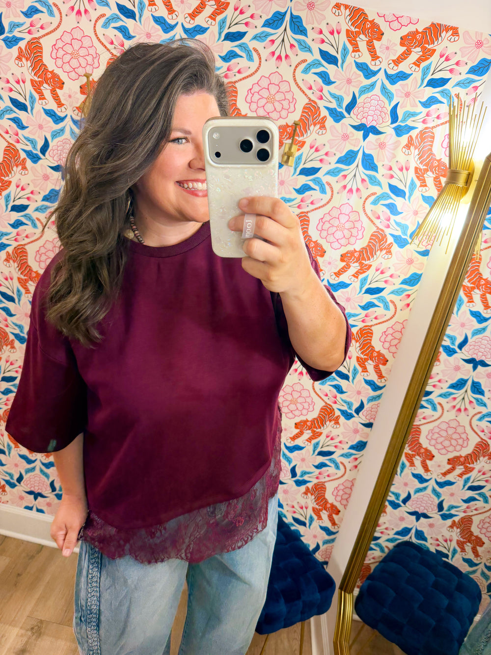  This top features a relaxed silhouette with a delicate lace hem that adds the perfect feminine touch. 