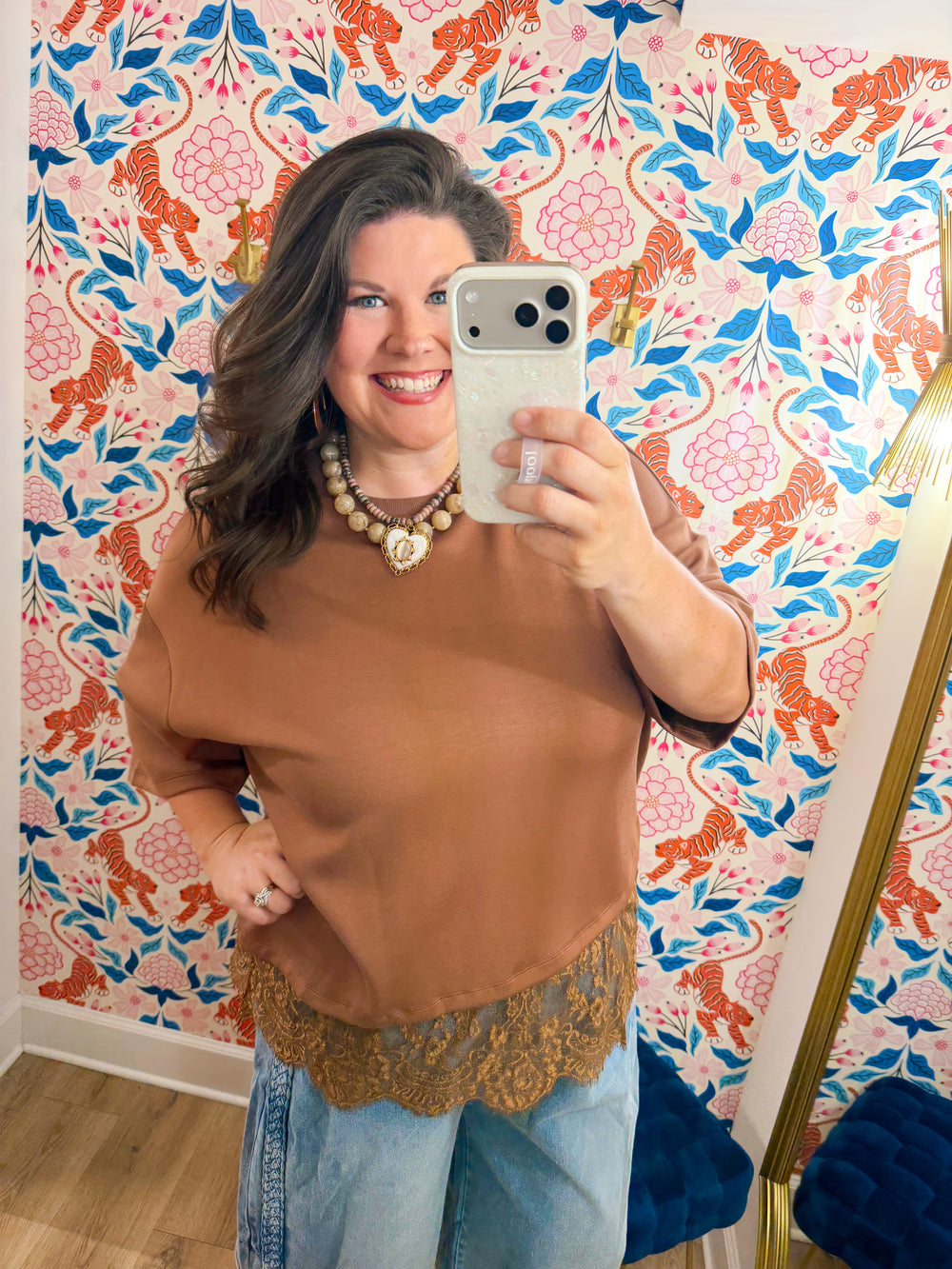  This top features a relaxed silhouette with a delicate lace hem that adds the perfect feminine touch. 