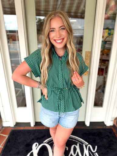 Green and navy striped top with cinching detail around the waist