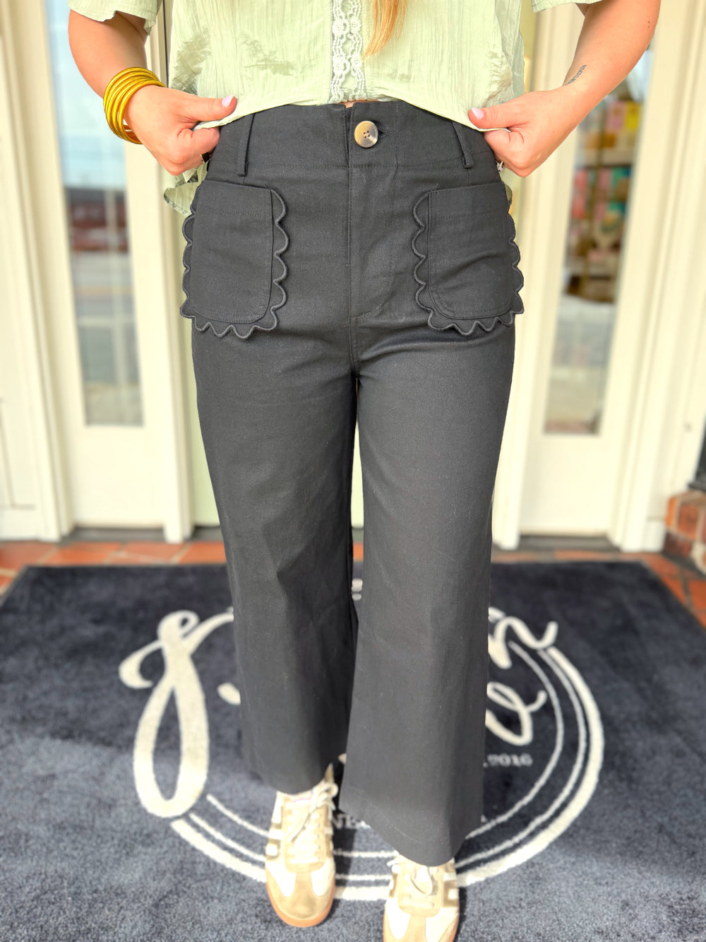 Black cropped pants with scallop pocket detailing.