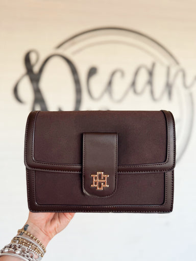 This rich chocolate brown handbag features a structured silhouette with a soft suede-inspired finish and smooth tonal trim. 