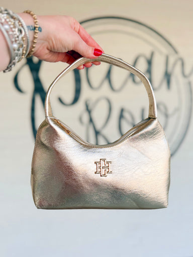 This gold handbag features a sleek, softly structured silhouette with a subtle textured finish and polished gold-tone hardware.