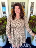 This mini dress features a feminine floral print with a flattering V-neckline, long sleeves, and an adjustable tie waist for added shape.