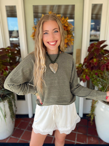 This olive green sweater features a textured ribbed knit, classic crew neckline, and relaxed fit for an easy everyday look.