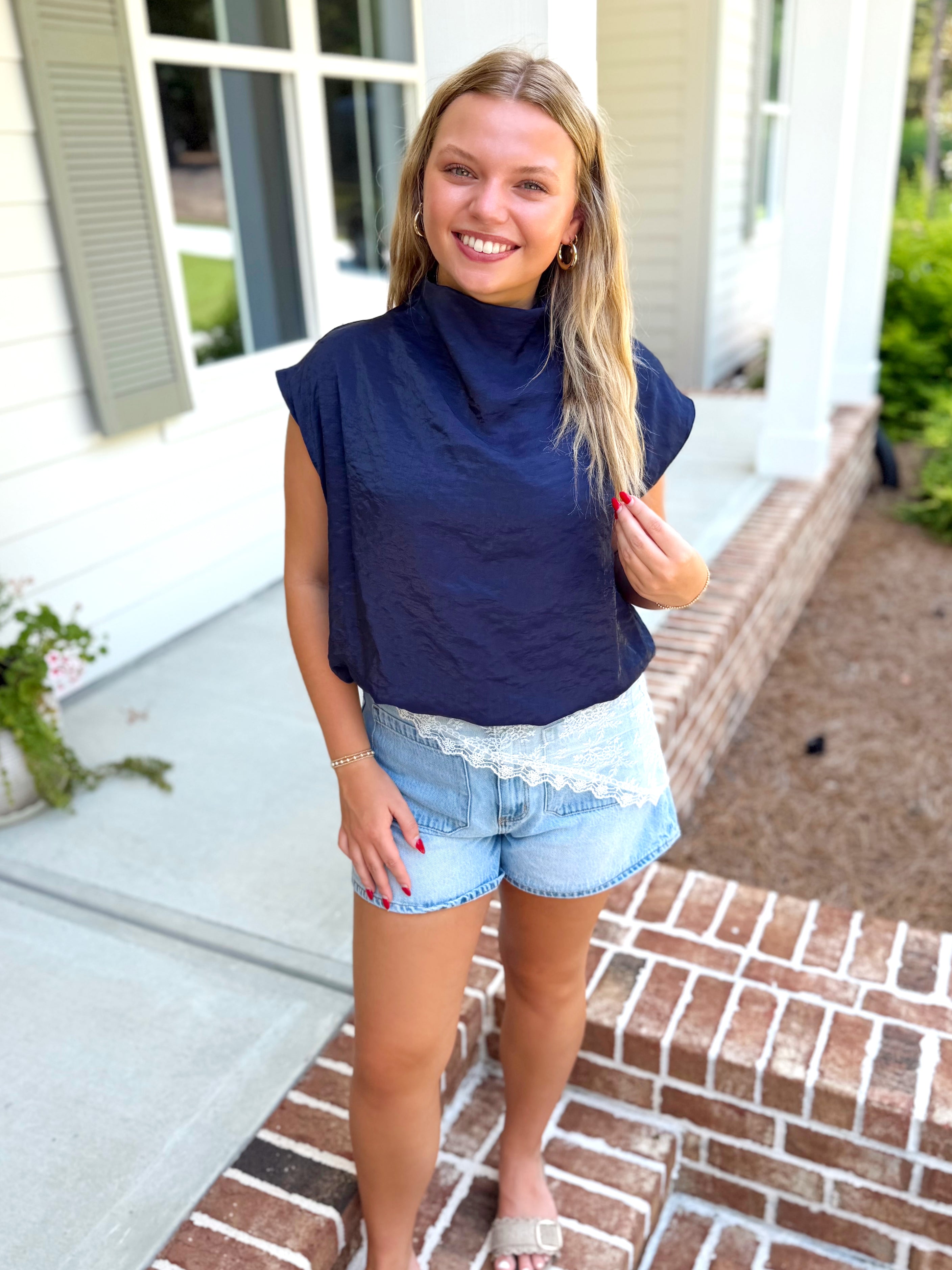 A navy blue sleeveless mock-neck balloon top.