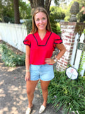 A short-sleeve blouse with black ruffle trim