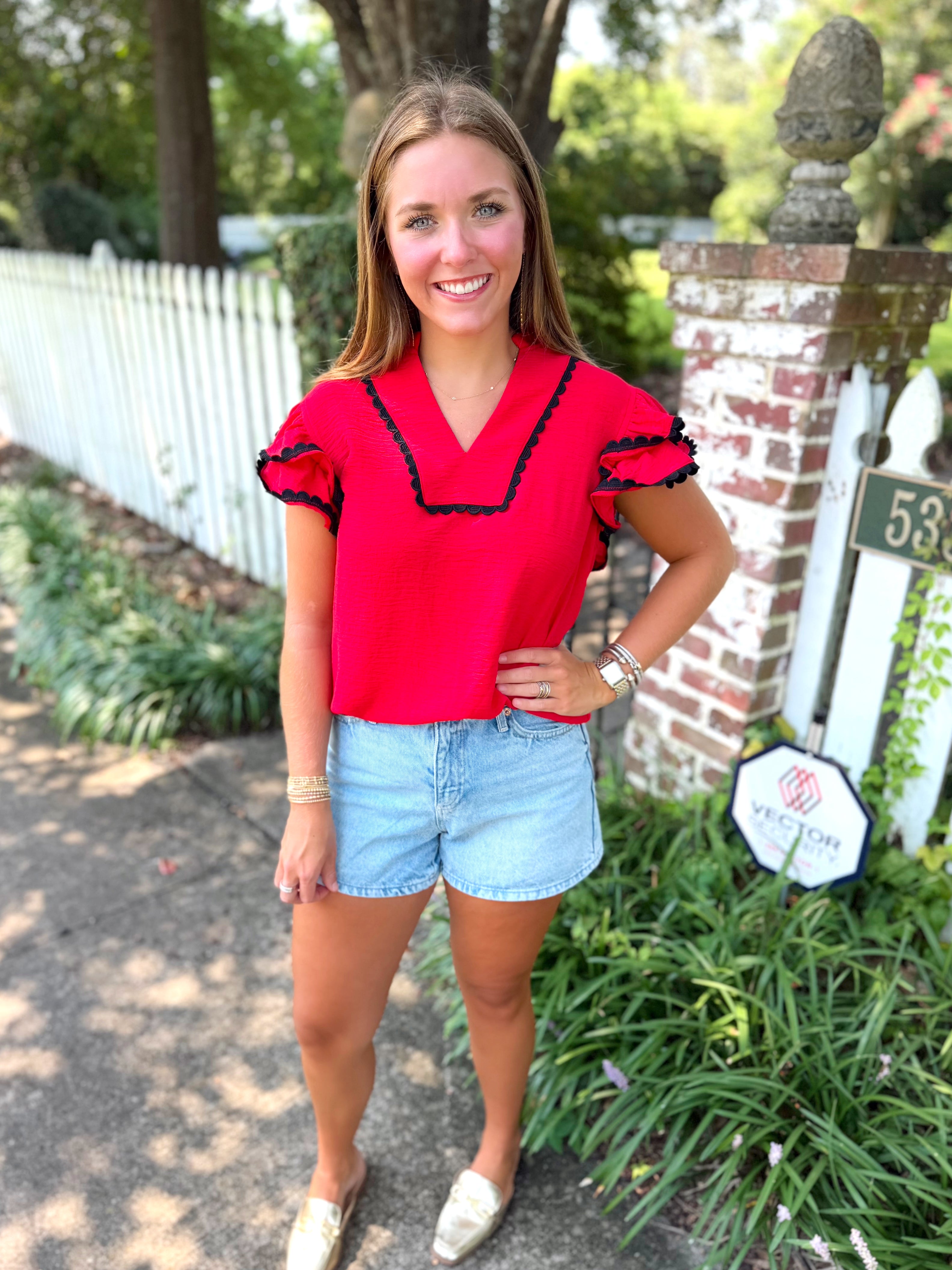 A short-sleeve blouse with black ruffle trim
