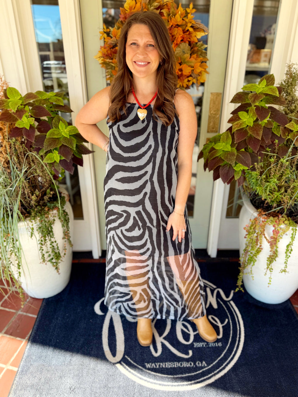 This black and gray zebra print maxi dress features a sleeveless design with a fitted, easy shape and sheer mesh detailing through the lower skirt.