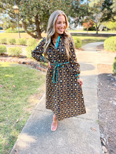 This features a rich black and warm golden floral-inspired print with contrasting green trim for an unexpected pop of color.