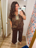  This rich chocolate brown top features a muted vintage-inspired floral print with olive, rust, and burgundy tones. 