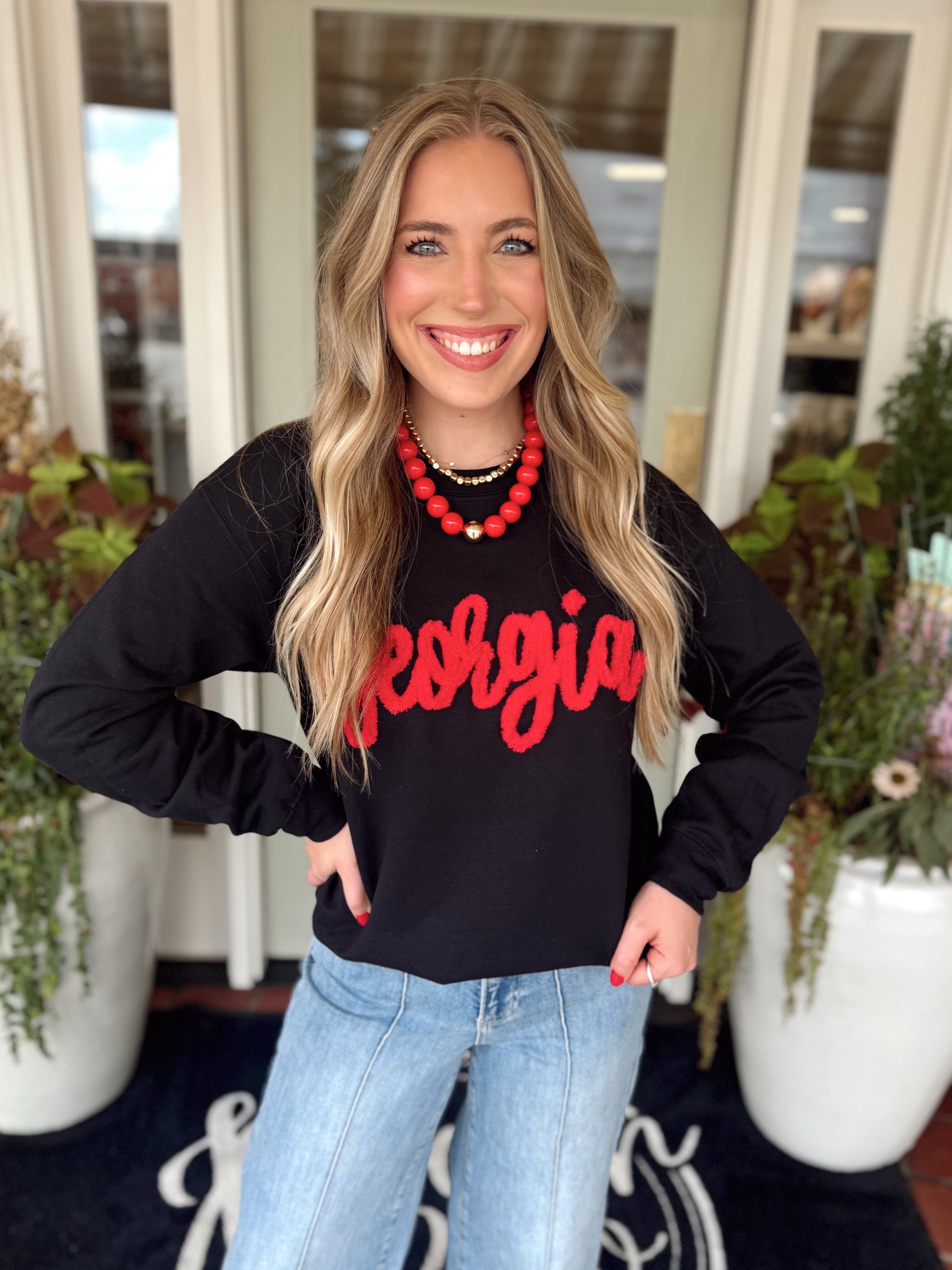 Black sweatshirt with puff yarn "Georgia" going across the front 