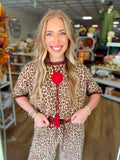  This top features an allover leopard print in warm brown and cream tones with a textured knit finish. 