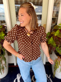  This chocolate brown top features an allover polka dot print with a feminine scoop neckline and statement puff sleeves. 