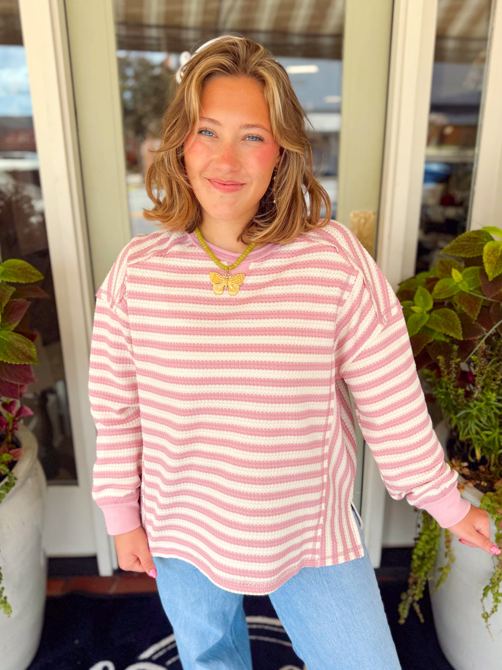 A pink and cream striped waffle knit top with a slit detailing on the sides 