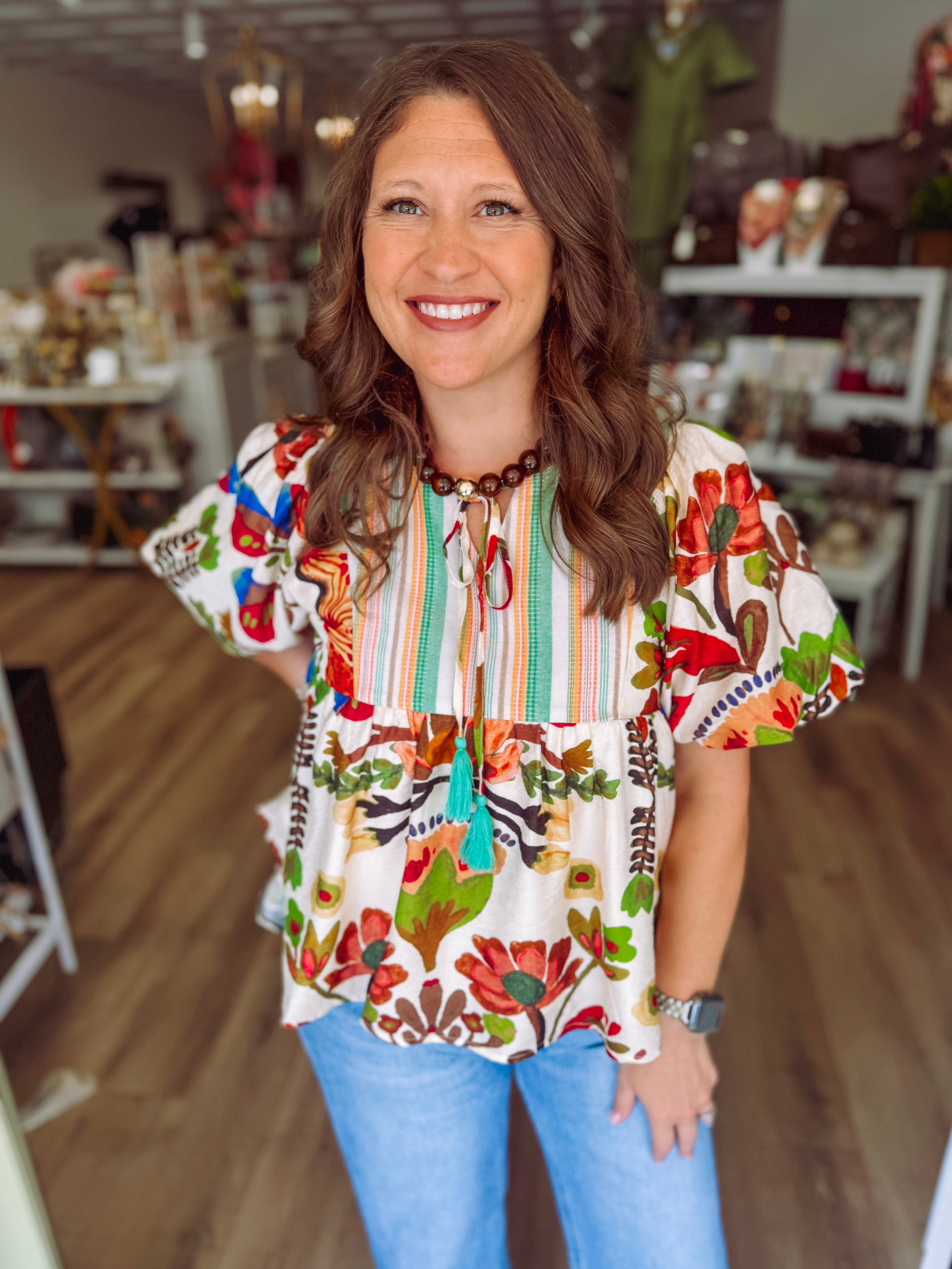 Colorful floral top with puff sleeves and a tie detailing on the front 