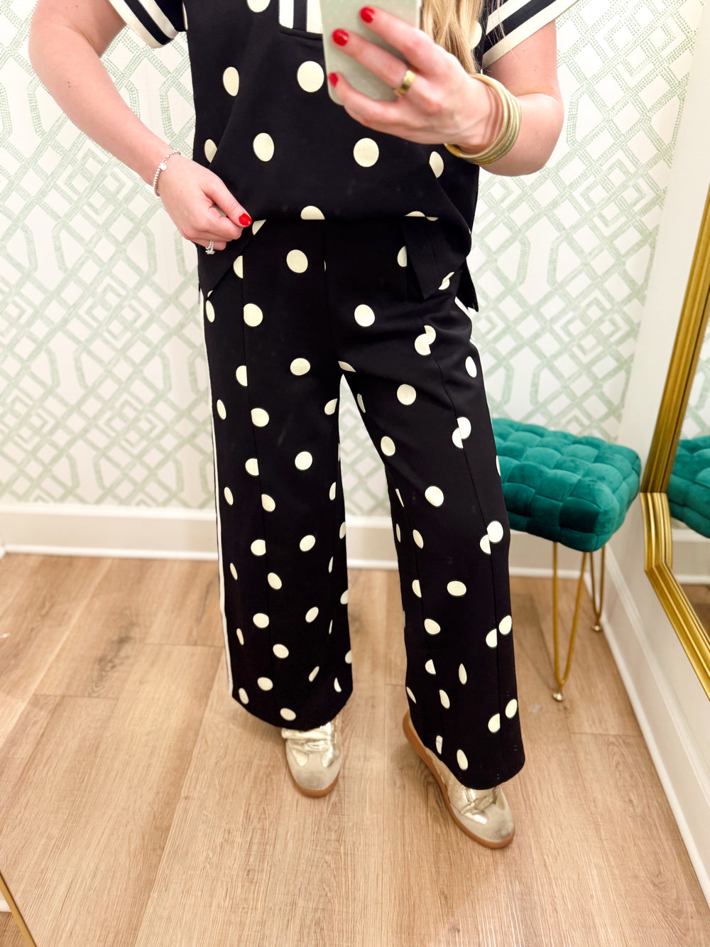 These black pants feature oversized cream polka dots, a flattering wide-leg silhouette, and contrast cream stripes down each side for a sporty finish.