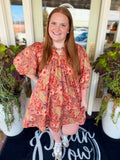 This babydoll mini dress features an oversized botanical print with voluminous puff sleeves and elastic cuffs.