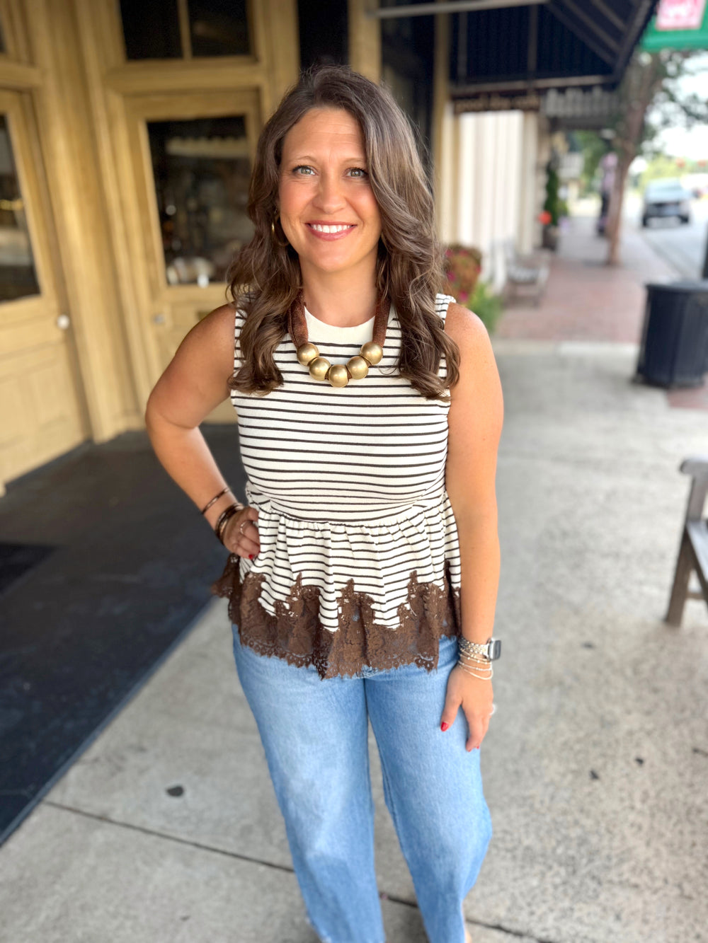 A sleeveless top with horizontal brown and cream stripes, and a brown ruffled hem.