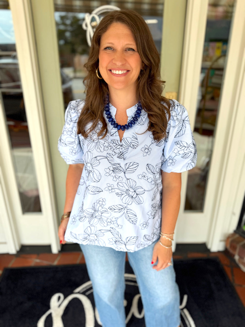 Light blue short-sleeve blouse with a floral line print