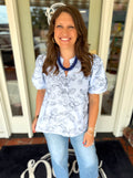 Light blue short-sleeve blouse with a floral line print