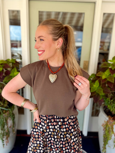  This mocha short sleeve top features a clean crew neckline with a relaxed silhouette and structured cap-style sleeves for a little extra shape. 