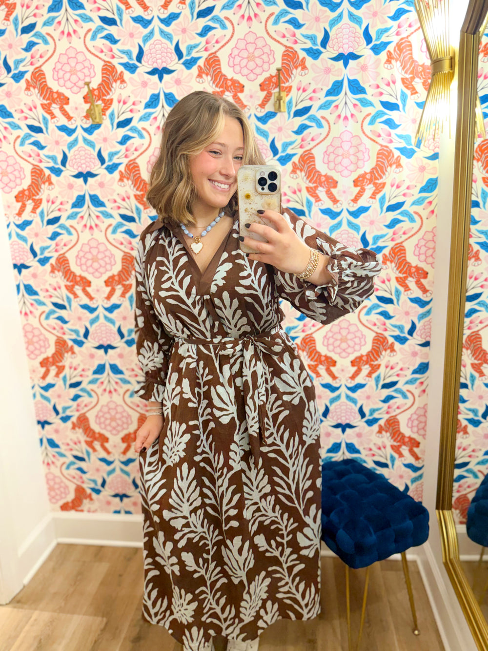 This brown midi dress features an oversized blue botanical print that gives it a fresh, elevated feel.