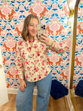 This blouse features a cream background with a mix of pink, red and olive florals, plus an easy popover neckline and feminine smocked cuffs