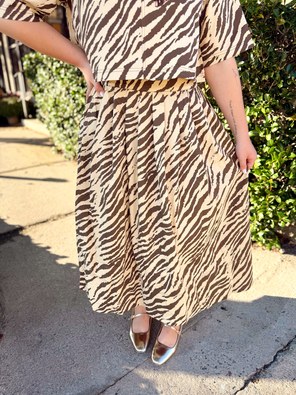 This cream and chocolate zebra print skirt features a full midi length with soft pleating that gives it plenty of movement and shape.