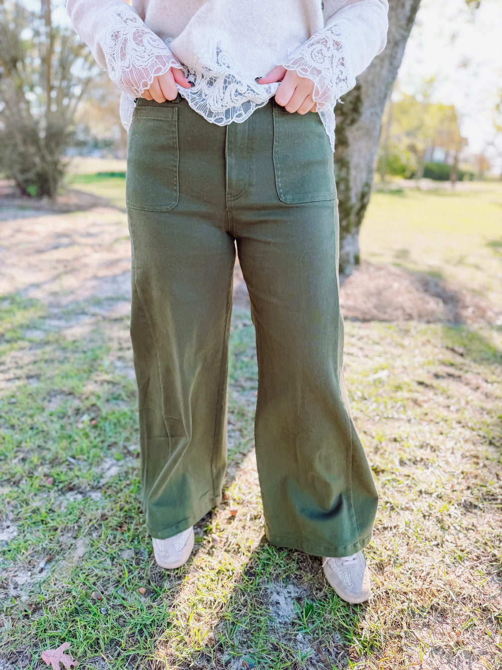 An easy everyday staple, these olive wide-leg pants feature a flattering high-rise waist, classic button-and-zip closure, and oversized front patch pockets.