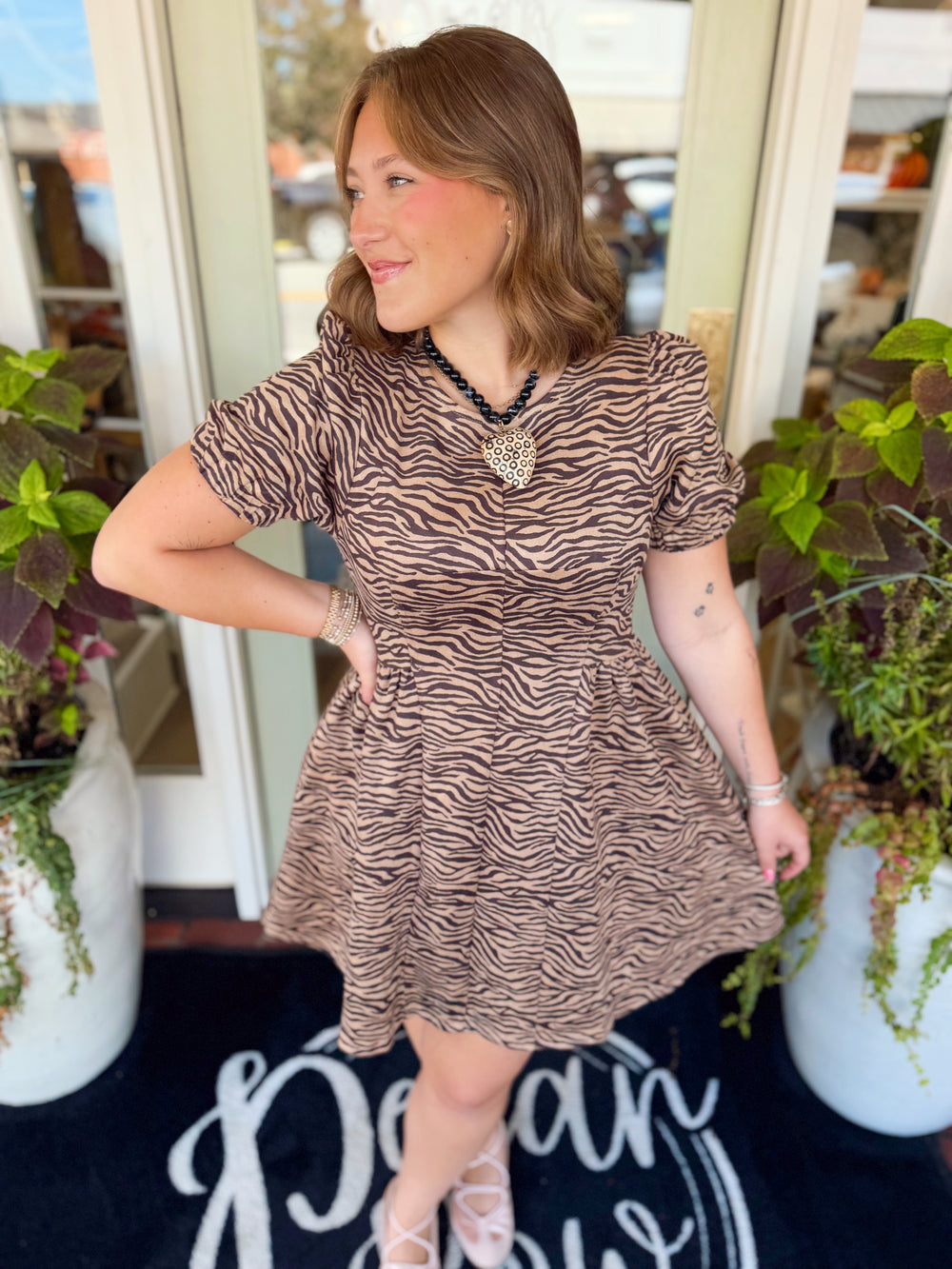 This lightweight mini dress features a bold allover print with short puff sleeves and a simple round neckline for an easy, flattering look.